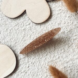 Barrette en résine décorée de paillettes dorées, parfaite pour ajouter une touche d'éclat à vos cheveux.