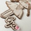 Poupette Princesse : Poupette gravée en bois avec fleurs séchées et paillettes, idéale pour les petits rêves étoilés.
