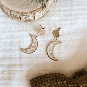 Boucles d’oreilles lune en résine transparente avec feuilles d'or, montées sur acier inoxydable. Bijou fait main, élégant et poétique.