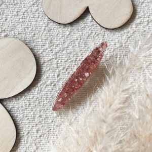 Barrette en résine décorée de paillettes roses, parfaite pour ajouter une touche d'éclat à vos cheveux.