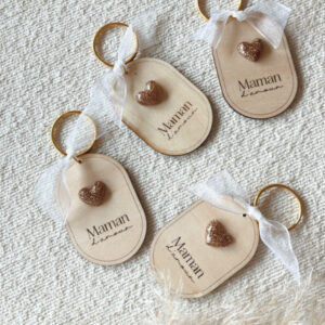 Porte-clés en bois gravé 'Maman d'Amour' avec un cœur en résine dorée et un ruban blanc. Création artisanale.
