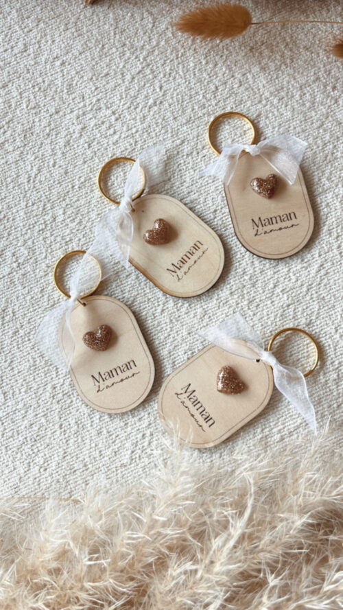 Porte-clés en bois gravé 'Maman d'Amour' avec un cœur en résine dorée et un ruban blanc. Création artisanale.