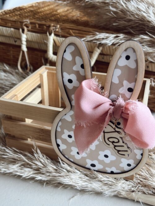 Caissette en bois pour cadeau de Pâques personnalisable avec un lapin décoratif en bois orné d'un ruban rose et d'un motif floral.