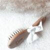 Brosse pour bébé en bois naturel, finement gravée avec le nom de bébé. Parfaite comme cadeau de naissance unique et plein d'amour, cette brosse bébé artisanale est ornée d'un nœud blanc délicat. Idéale pour les soins délicats de votre nouveau-né, elle allie élégance et praticité.