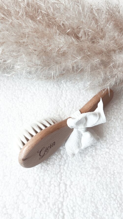 Brosse pour bébé en bois naturel, finement gravée avec le nom de bébé. Parfaite comme cadeau de naissance unique et plein d'amour, cette brosse bébé artisanale est ornée d'un nœud blanc délicat. Idéale pour les soins délicats de votre nouveau-né, elle allie élégance et praticité.