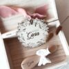 Médaillon bienvenue bébé en bois naturel, finement gravé avec le nom de bébé et orné d'un ruban délicat et de son petit coeur. Ce médaillon est parfait comme cadeau de naissance personnalisé ou comme décoration pour la chambre de bébé. Chaque pièce est unique et artisanale, idéale pour un souvenir de naissance spécial et plein d'amour.