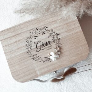Valisette "Mes Premiers Souvenirs" en bois naturel, finement gravée avec le nom de bébé et ornée de fleurs séchées. Cette boîte à souvenirs est parfaite pour conserver les premiers moments précieux de bébé. Idéale comme cadeau de naissance personnalisé, elle allie élégance et sentimentalité.