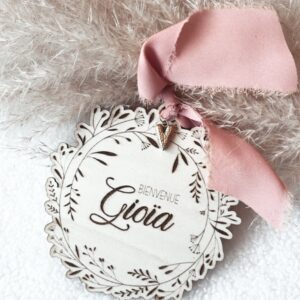 Médaillon bienvenue bébé en bois naturel, finement gravé avec le nom de bébé et orné d'un ruban délicat et de son petit coeur. Ce médaillon est parfait comme cadeau de naissance personnalisé ou comme décoration pour la chambre de bébé. Chaque pièce est unique et artisanale, idéale pour un souvenir de naissance spécial et plein d'amour.