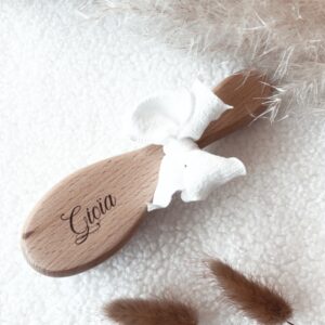 Brosse pour bébé en bois naturel, finement gravée avec le nom de bébé. Parfaite comme cadeau de naissance unique et plein d'amour, cette brosse bébé artisanale est ornée d'un nœud blanc délicat. Idéale pour les soins délicats de votre nouveau-né, elle allie élégance et praticité.